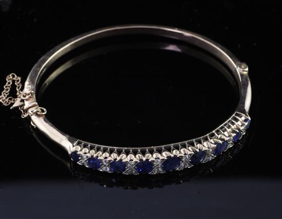 An Edwardian gold, sapphire and diamond hinged bangle,